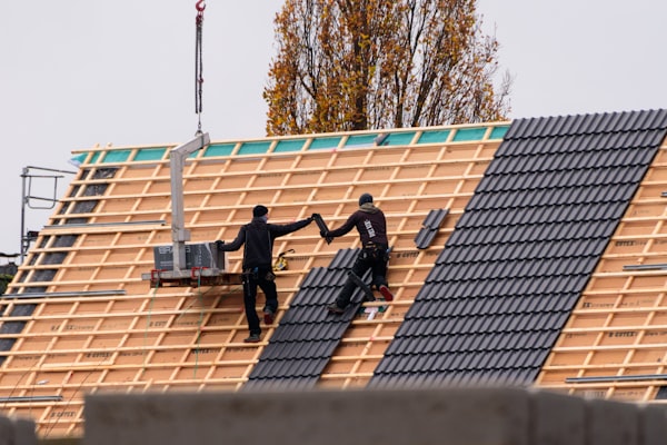 Workers installing new roof tiles during restoration project
